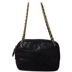 80's vintage CHANEL black lambskin classic bag with golden chains and cc charm.
