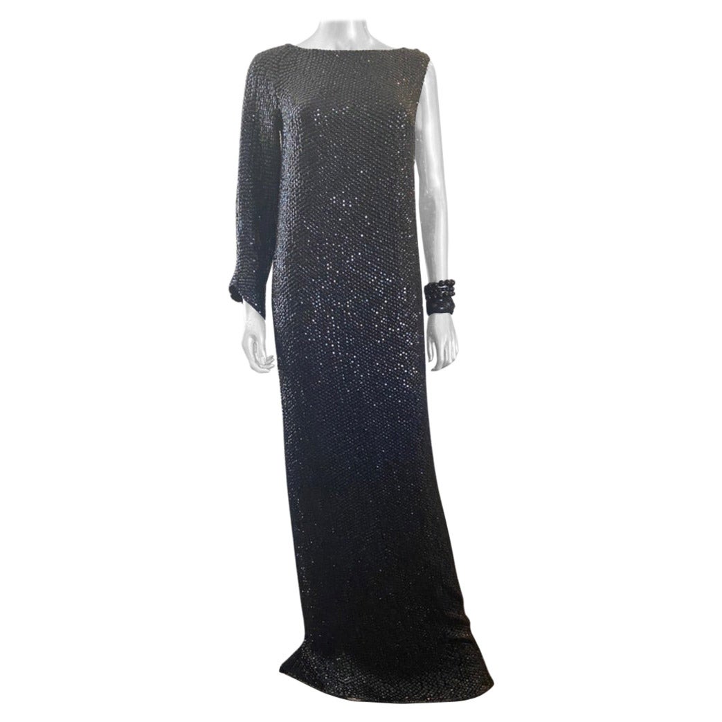 A showstopper. I’ve never seen a more modern or Luxe design by Escada as this gown. The entire gown is hand-beaded in faceted black jet beads. The drama comes from one long sleeve on the left arm and sleeveless right side. It even has hidden slit