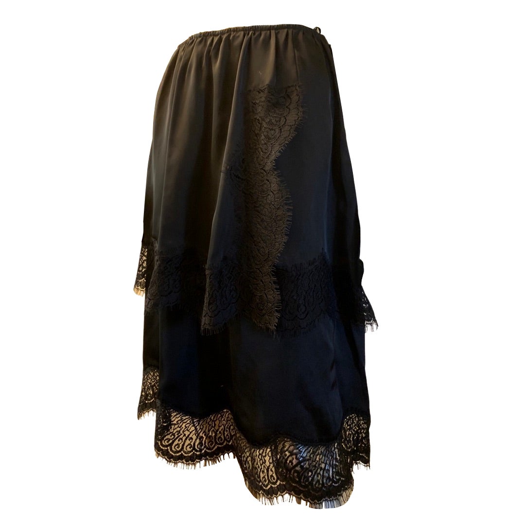 A very chic black lace skirt design by the house of Lanvin, Paris. Skirt is made in European acetate with imported lace trim. Slightly gathered at the waist the skirt is designed with a two tier panels with lace hem and front side. French size 40.