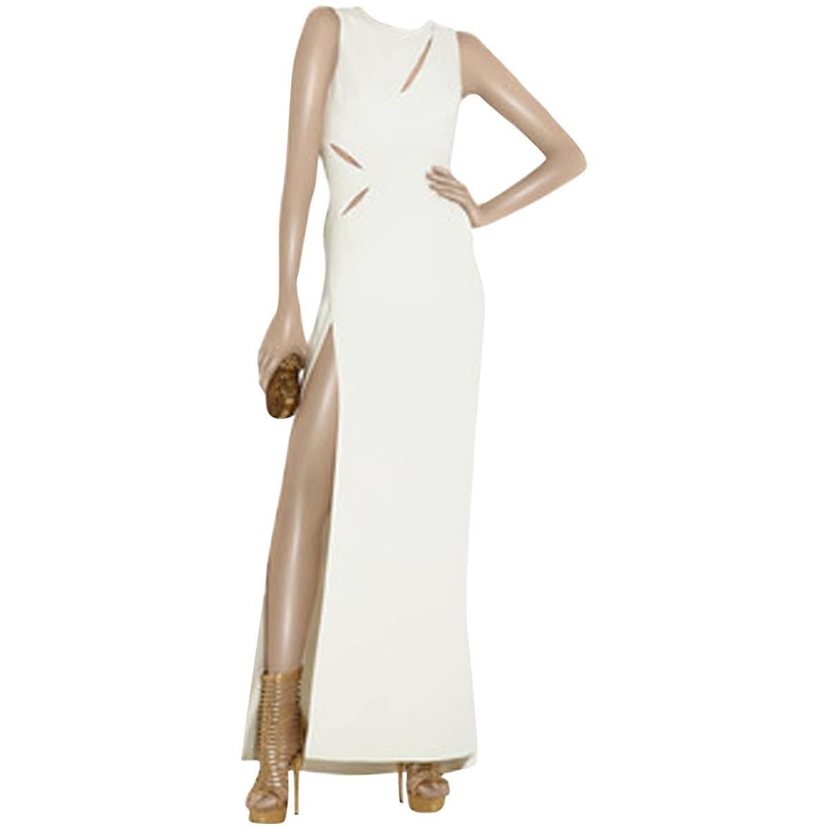 White silk-cady full-length sleeveless gown with cutout detailing at front, back and side. Versace gown has a thigh-high vent at side, round neck, flared skirt, is slightly fitted at the waist, has a concealed zip fastening at the side and is