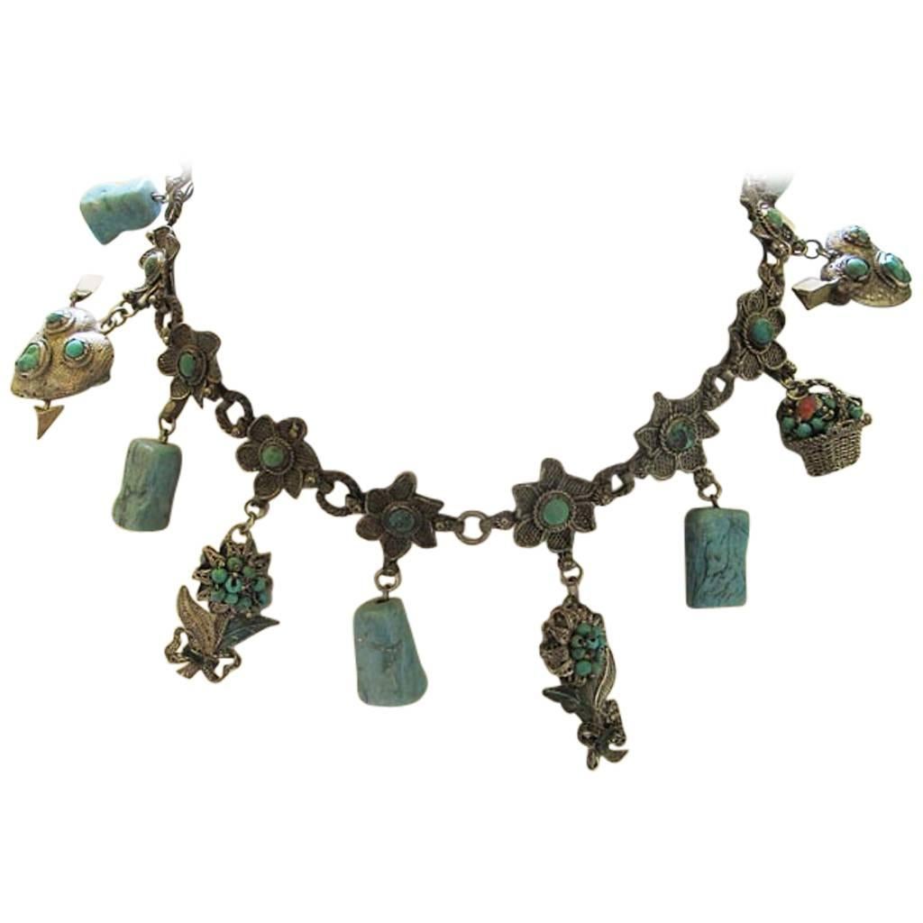 This beautiful vintage silver plate and turquoise floral choker has a potpourri of turquoise-embellished charms with flower and heart designs. It comes from the collection of a Grande Dame of Hillsborough California.

YOUR PURCHASE BENEFITS THOSE