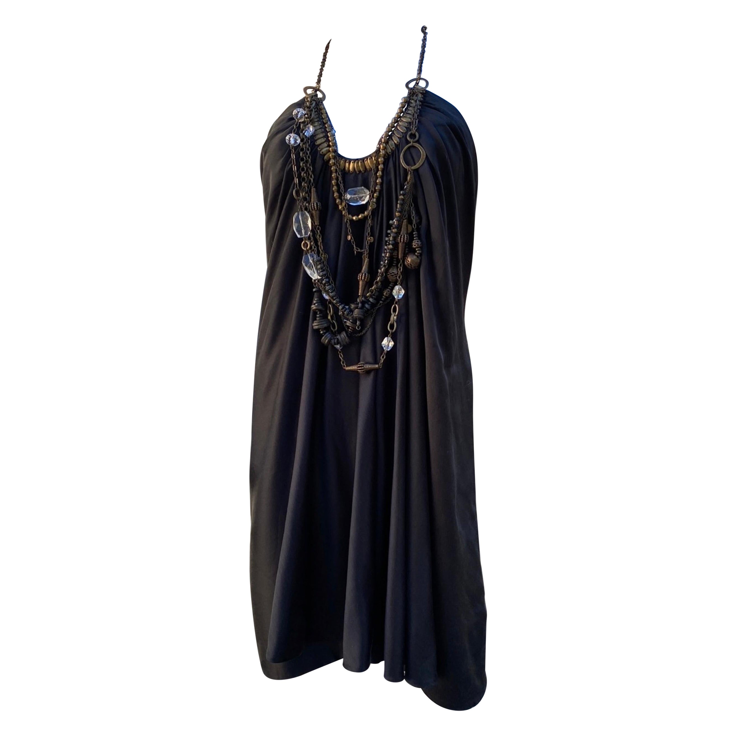 This dress is one of our favorite listings. The design by KaufmanFranco was loved by the fashion editors worldwide. The dress itself is beautiful, draped front black silk with hand beaded gold metal detail. What transcends the dress to spectacular