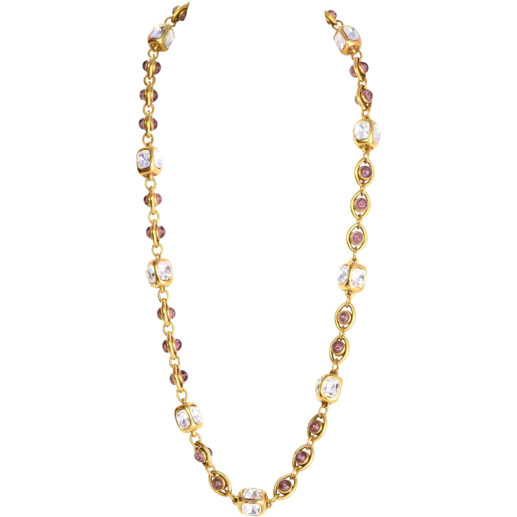 Chanel Purple Gripoix & Crystal Necklace
Features cubes with crystal & circular pendants with gripoix details throughout chain link 
Made In: France
Year of Production: 1986
Color: Goldtone, purple, and clear
Materials: Metal, crystal
