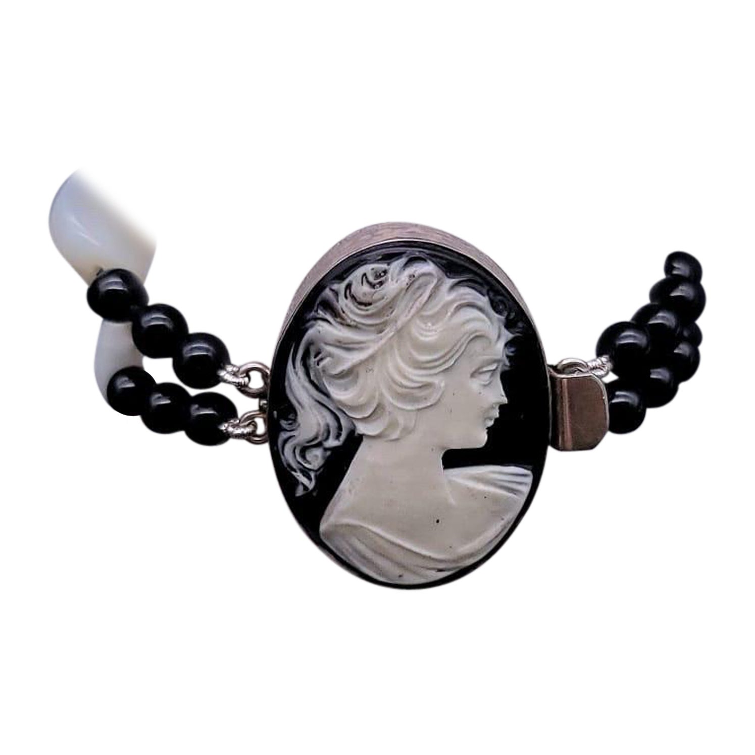 One-of-a-Kind
Make a statement with this stunning black and white bracelet. Featuring a mix of mother-of-pearl and polished Onyx beads, this bracelet is truly unique. The strong carved onyx cameo adds a powerful touch to the design, mounted in a