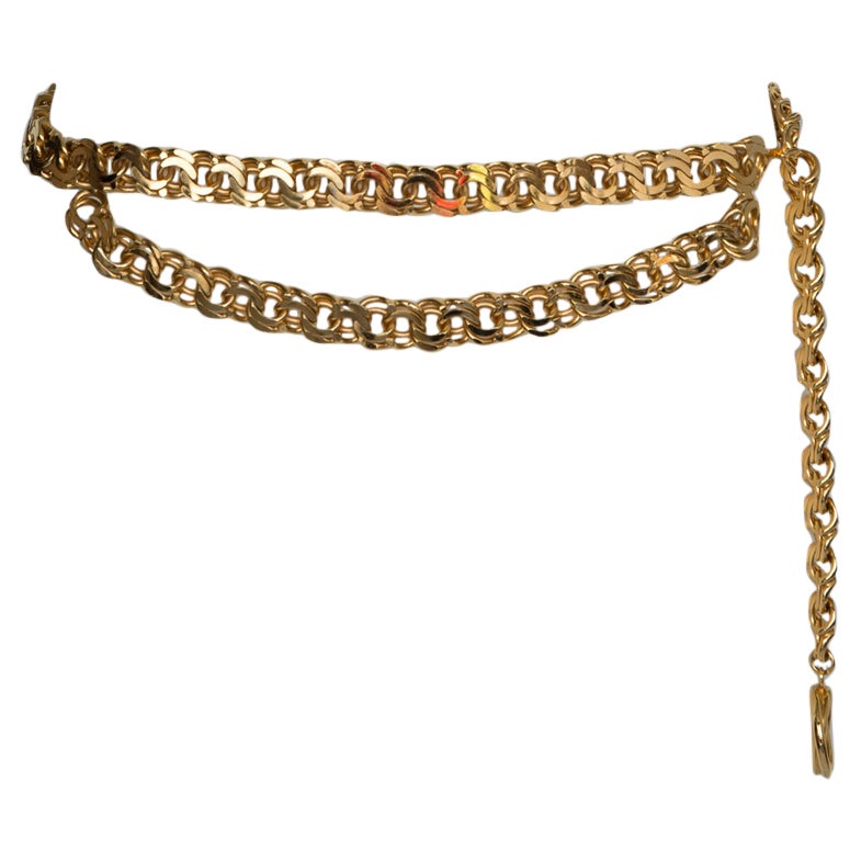 Ceinture intemporelle Chanel de la fin des années 80 - début des années 90 à double chaîne plaquée or avec médaillon emblématique du logo CC. La ceinture se ferme à l'aide d'un crochet qui permet d'ajuster la longueur à une gamme de tailles. Signé