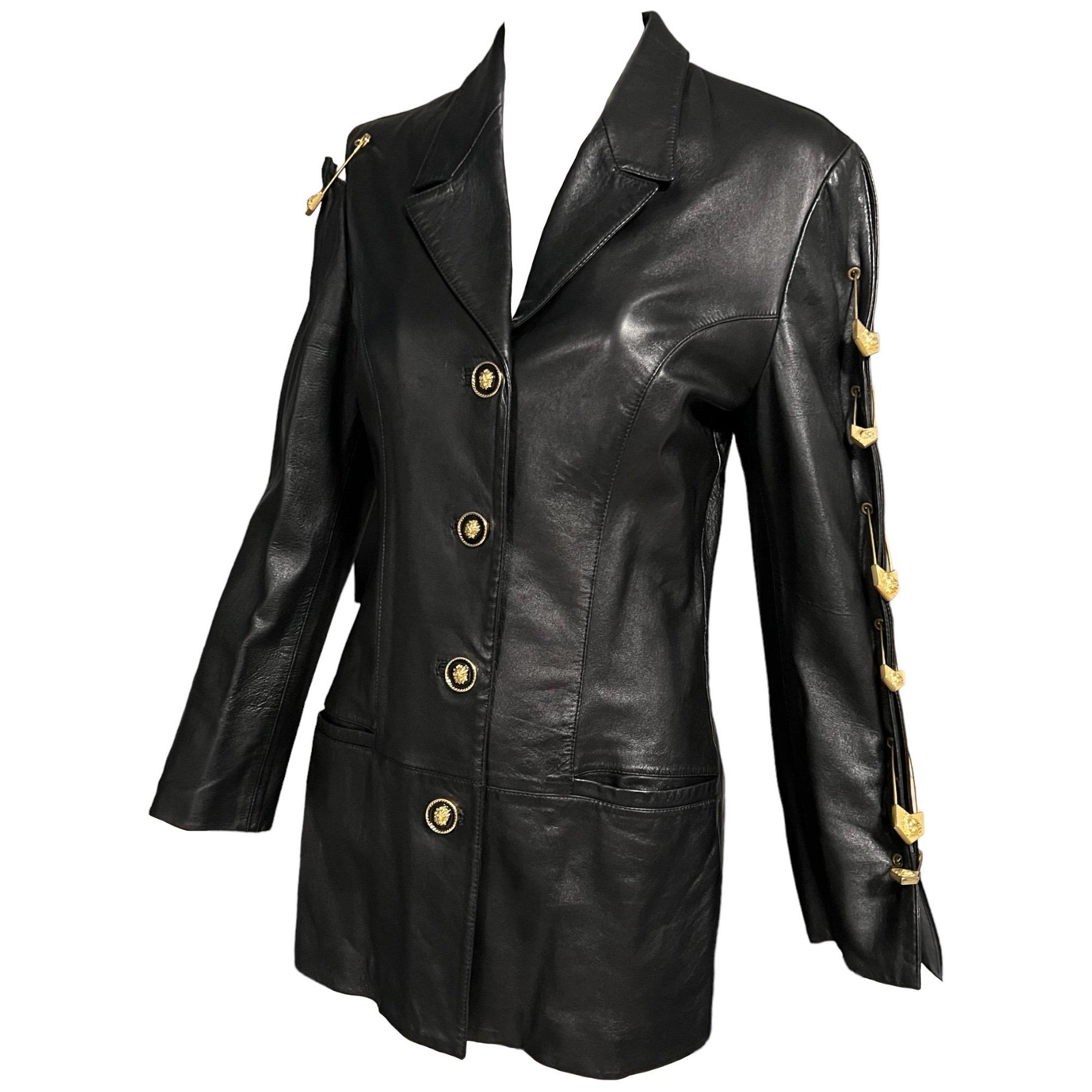 Iconic rare Versus Gianni Versace black leather safety pin blazer
Soft black leather with slit detailing on the sleeve and cutout detail on the shoulder.
Gold and black lion head buttons
Extra large gold lion head safety pins embellishments adorn