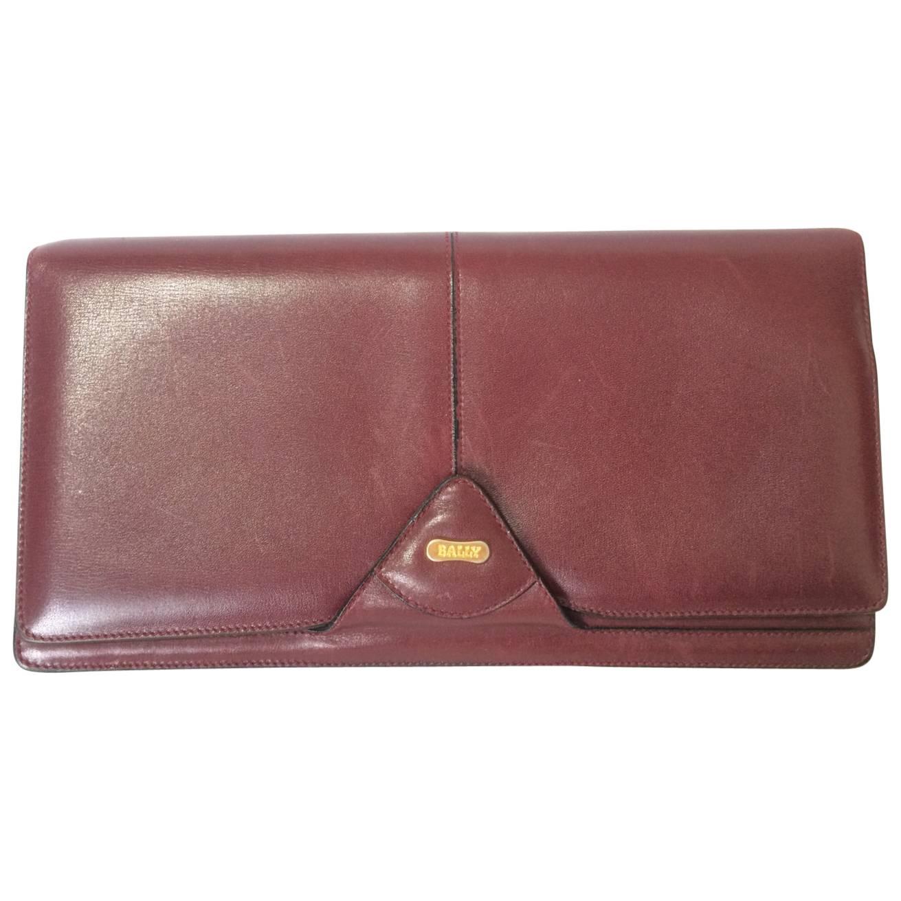 Vintage Bally wine leather clutch bag, party and classic purse with golden logo. For Sale