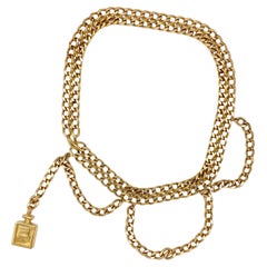 Used chain belt, draped with Chanel perfume bottle