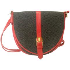 Used Yves Saint Laurent oval navy shoulder bag with red shoulder straps.