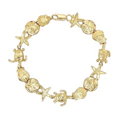 Bracelet à maillons en or avec dollar des sables, étoile de mer, coquillage, palourde et tortue de mer