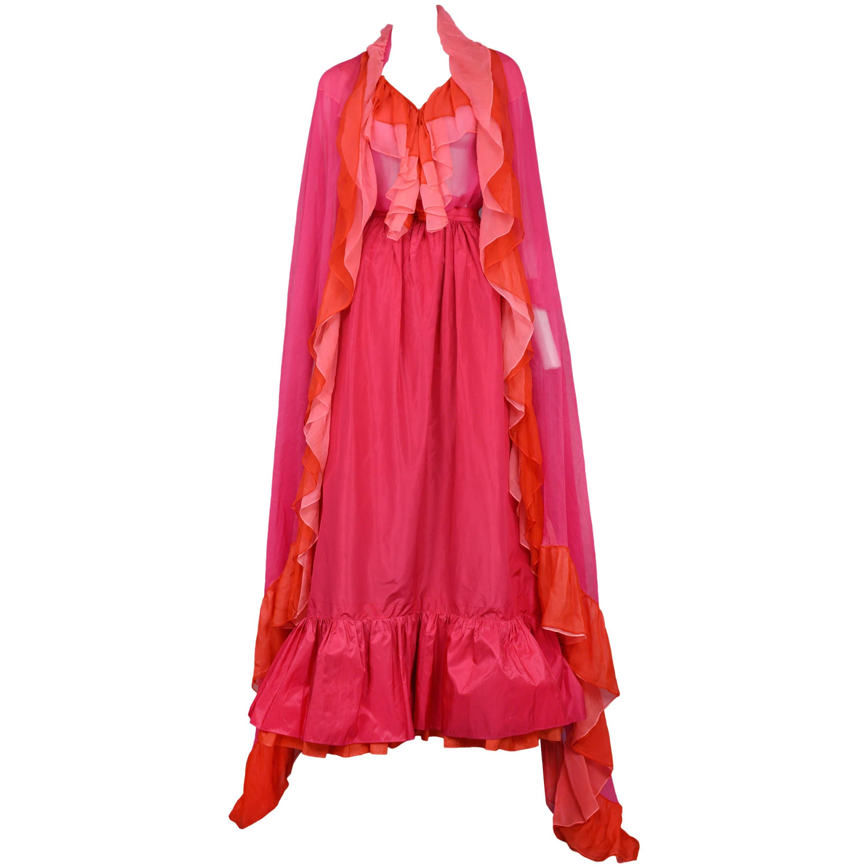 Vintage Yves Saint Laurent three piece ensemble featuring a ruffle blouse and ruffle shawl comprised of fuchsia, pink and red chiffon. The look is completed with a matching fuchsia taffeta ball skirt featuring a red double layer flounce at the