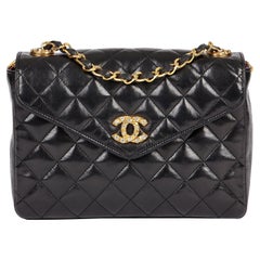 CHANEL Mini sac à rabat vintage en cuir d'agneau matelassé noir orné de cristaux