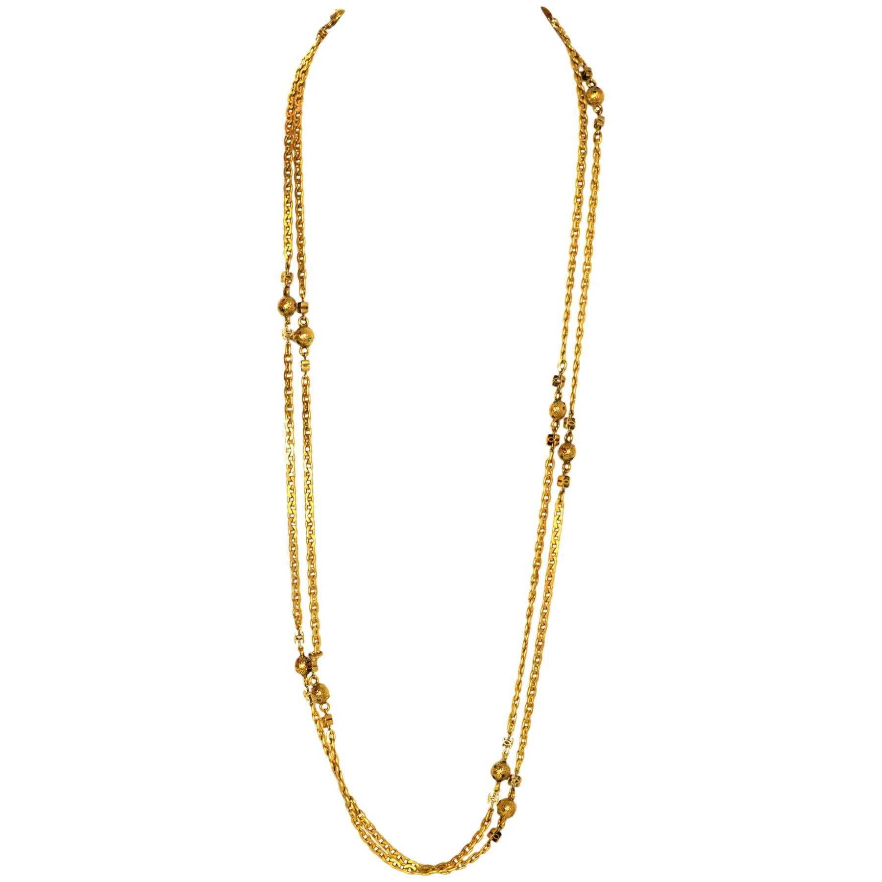 Features flat chain-link strand, CC ornaments and mini ball ornaments with pave milticolor stones

Made in: France
Year of Production: 1982
Stamp: CHANEL CC 1982  MADE IN FRANCE
Closure: Push tab closure
Color: Goldtone
Materials: Metal and