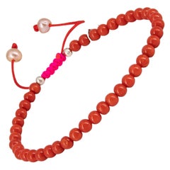 Red coral bracelet with neon pink drawstring closure and freshwater pearls