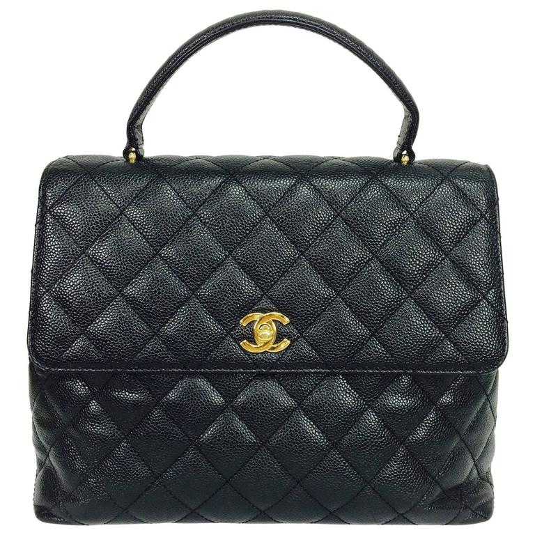 Vintage Chanel top handle flap front black caviar leather handbag at