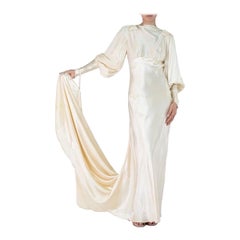 Robe de mariée à traîne et manches bouffantes en satin de soie crème des années 1930