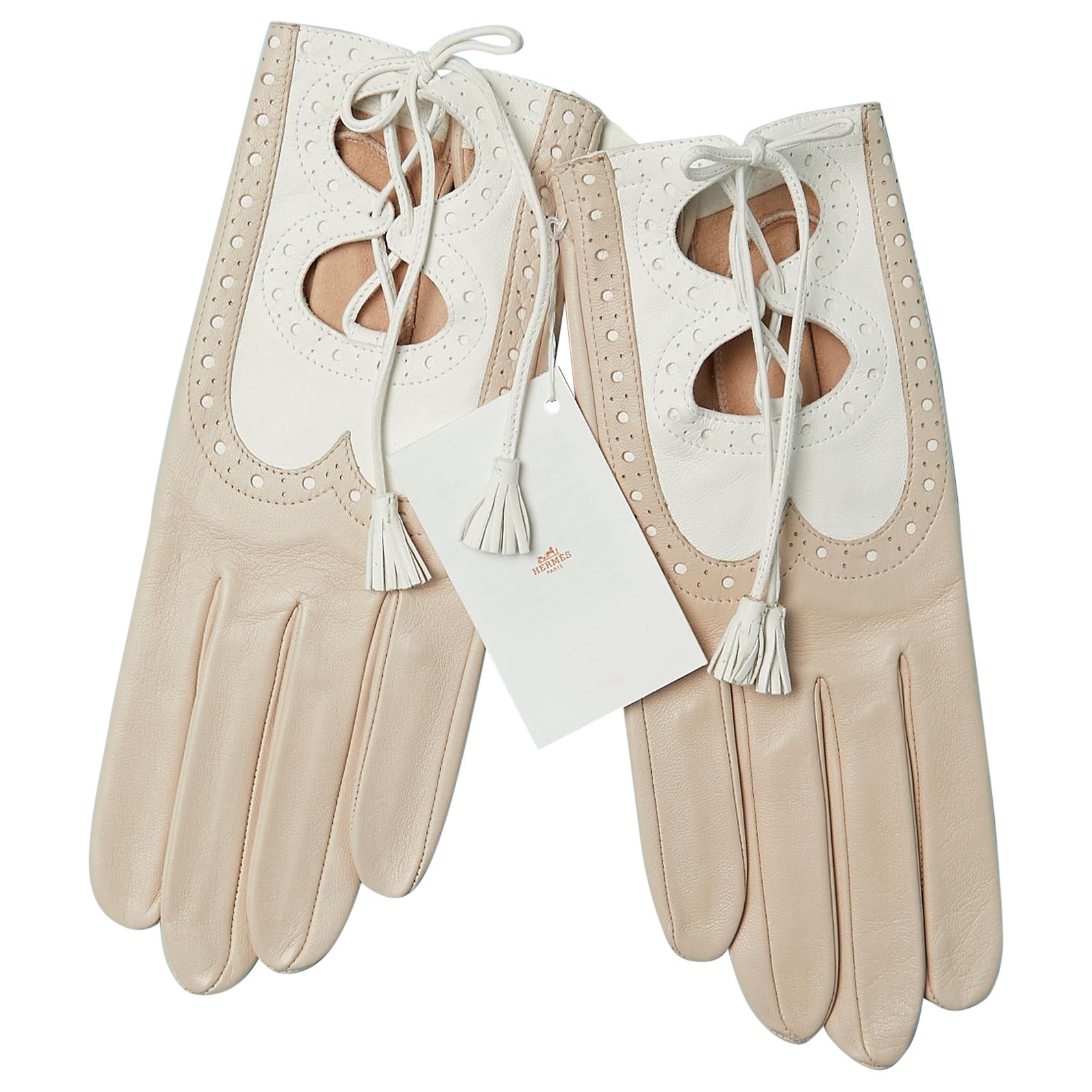 Beigefarbene und weiße Lederhandschuhe mit Schnittmuster, Lederschnürung und Pompon Hermès  im Angebot