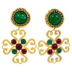 Moschino - Boucles d'oreilles clips avec croix en métal doré et cabochons rouges et verts