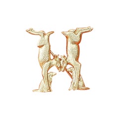 Broche en métal doré représentant des chiens et des chats formant un H 