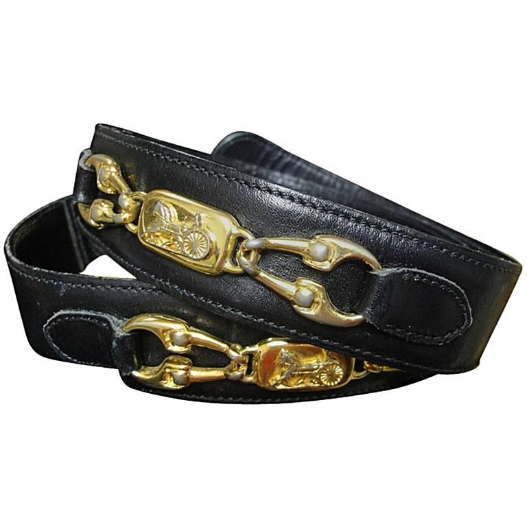 Vintage Celine black leather belt with golden carriage and horse motif. 65 