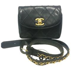 Vintage CHANEL black leather waist bag, fanny pack with golden chain belt.