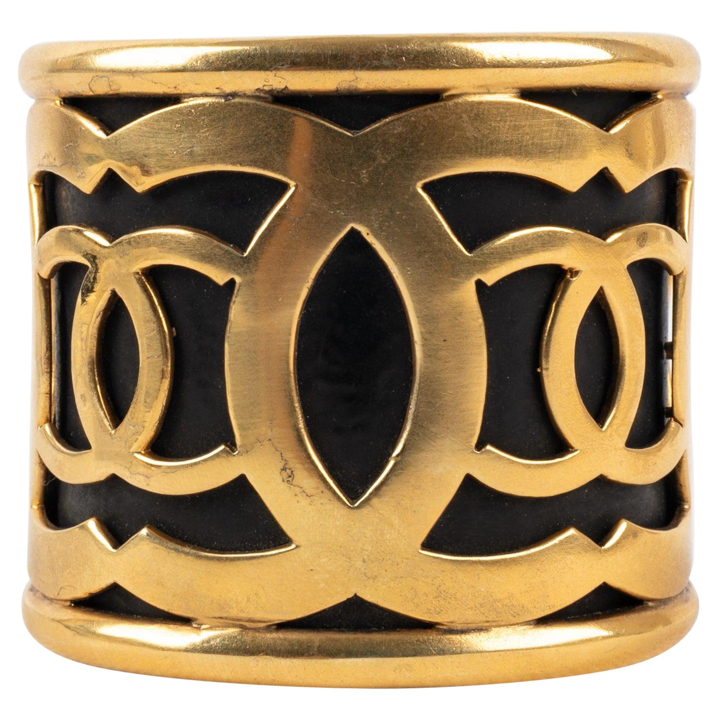 Chanel Manschettenarmband aus goldenem Metall auf schwarzem Hintergrund im Angebot