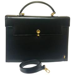 Vintage Roberta di Camerino black Kelly bag with golden logo and shoulder strap.