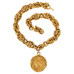 Impressionnant collier haute couture Chanel en métal plaqué or avec pendentif CC