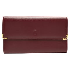 Portefeuille continental trifold en cuir Must de Cartier de couleur bourgogne