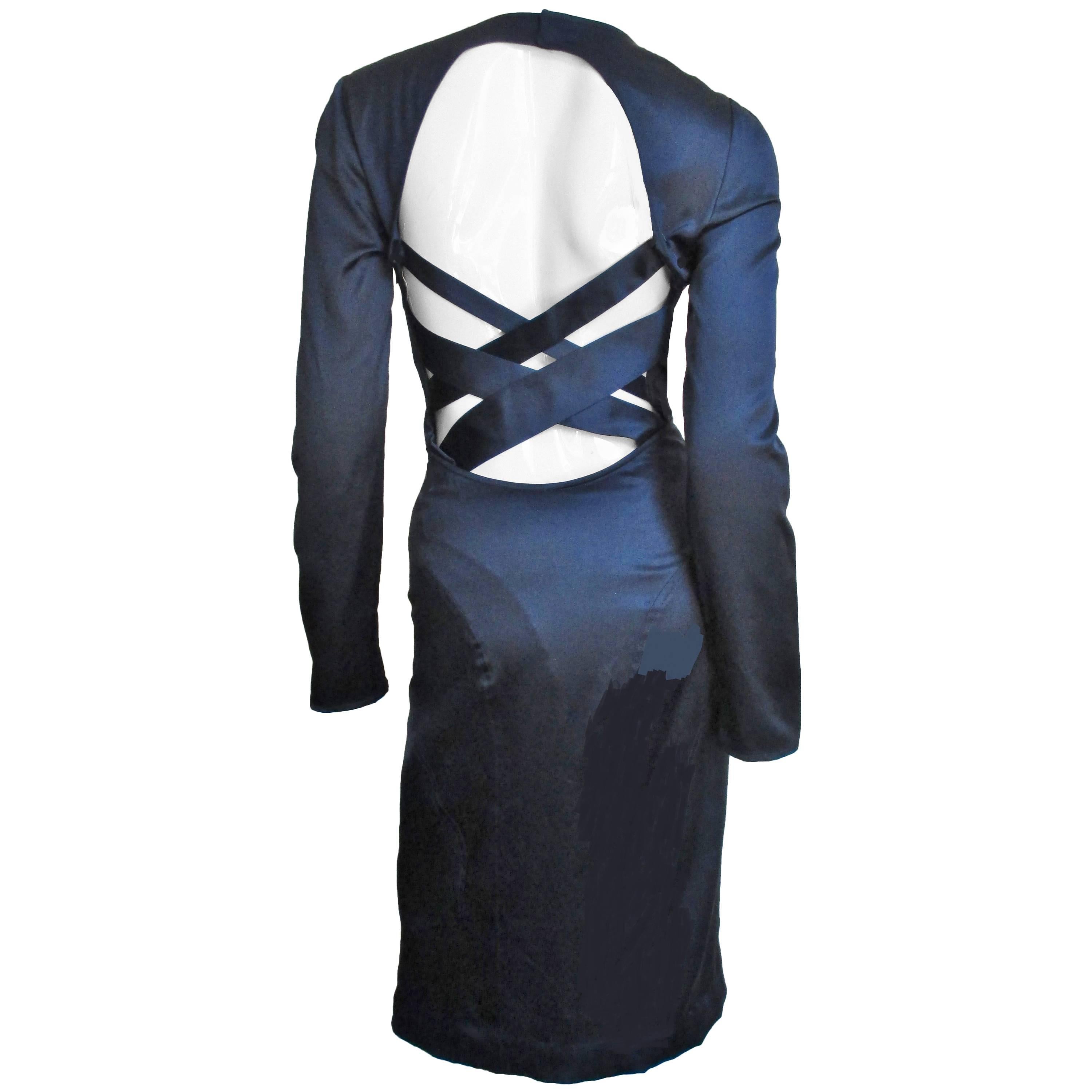 A fabulous navy silk dress with some stretch from Versace.  It is fitted with long sleeves and a scoop neckline. There are 3 flattering curved horizontal panels across the front below the bust line curving to form the back skirt and the back is