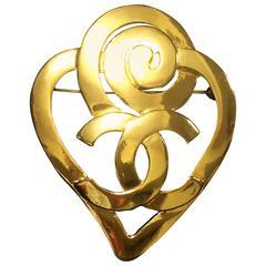 Retro CHANEL gold tone heart and snail design brooch with CC mark at center.