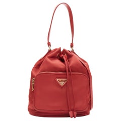 Prada, borsa a tracolla in nylon rosso con triangolo in oro, con coulisse e secchiello
