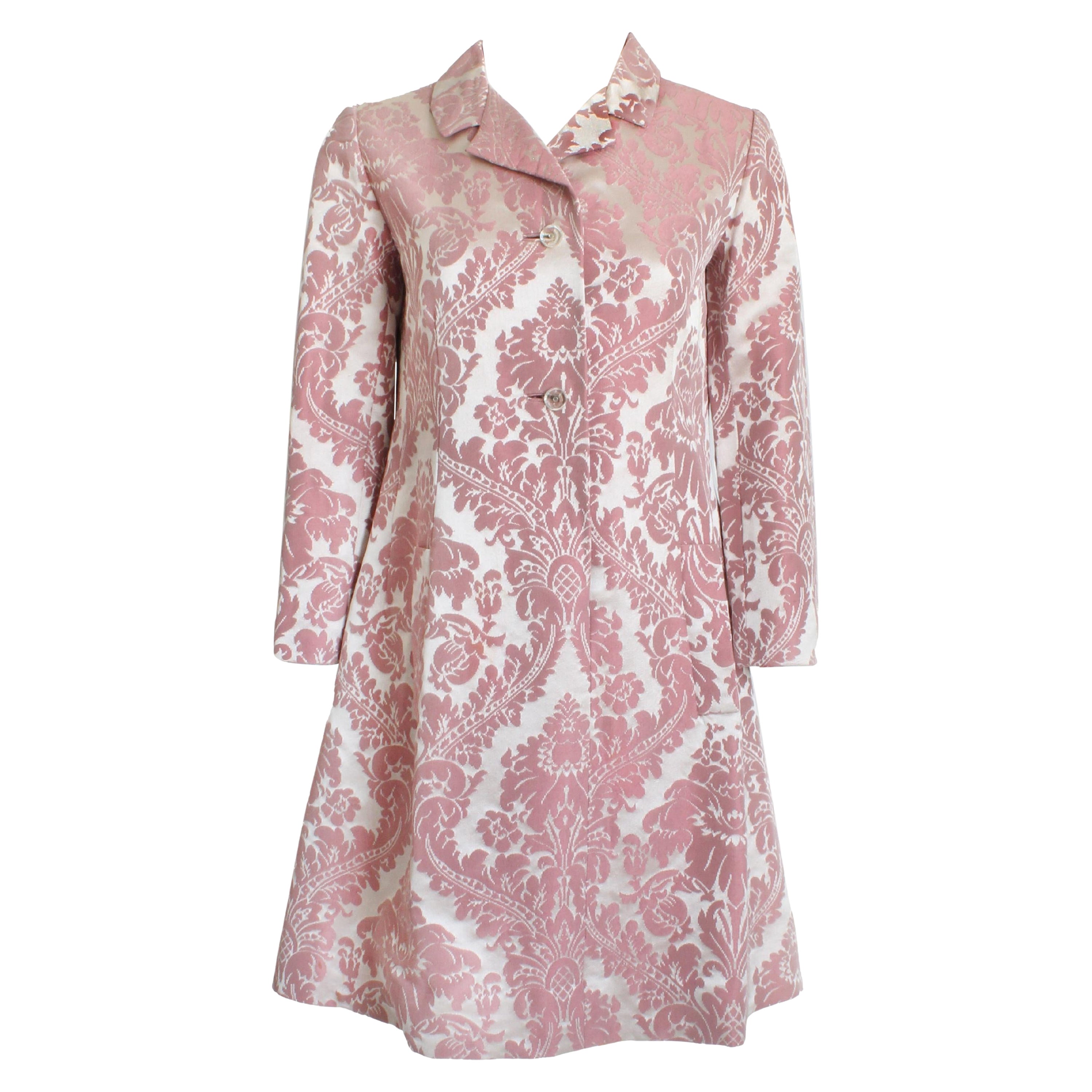 This fabulous coat dress was made by Chester Weinberg and sold by the Oval Room at Daytons, most likely in the mid 60s.   Made from a gorgeous pink floral damask, it has an incredible sheen to the fabric! It slips over the head and fastens with