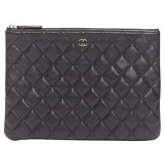 Chanel O Case, pochette con zip trapuntata in pelle liscia e matelassé nera