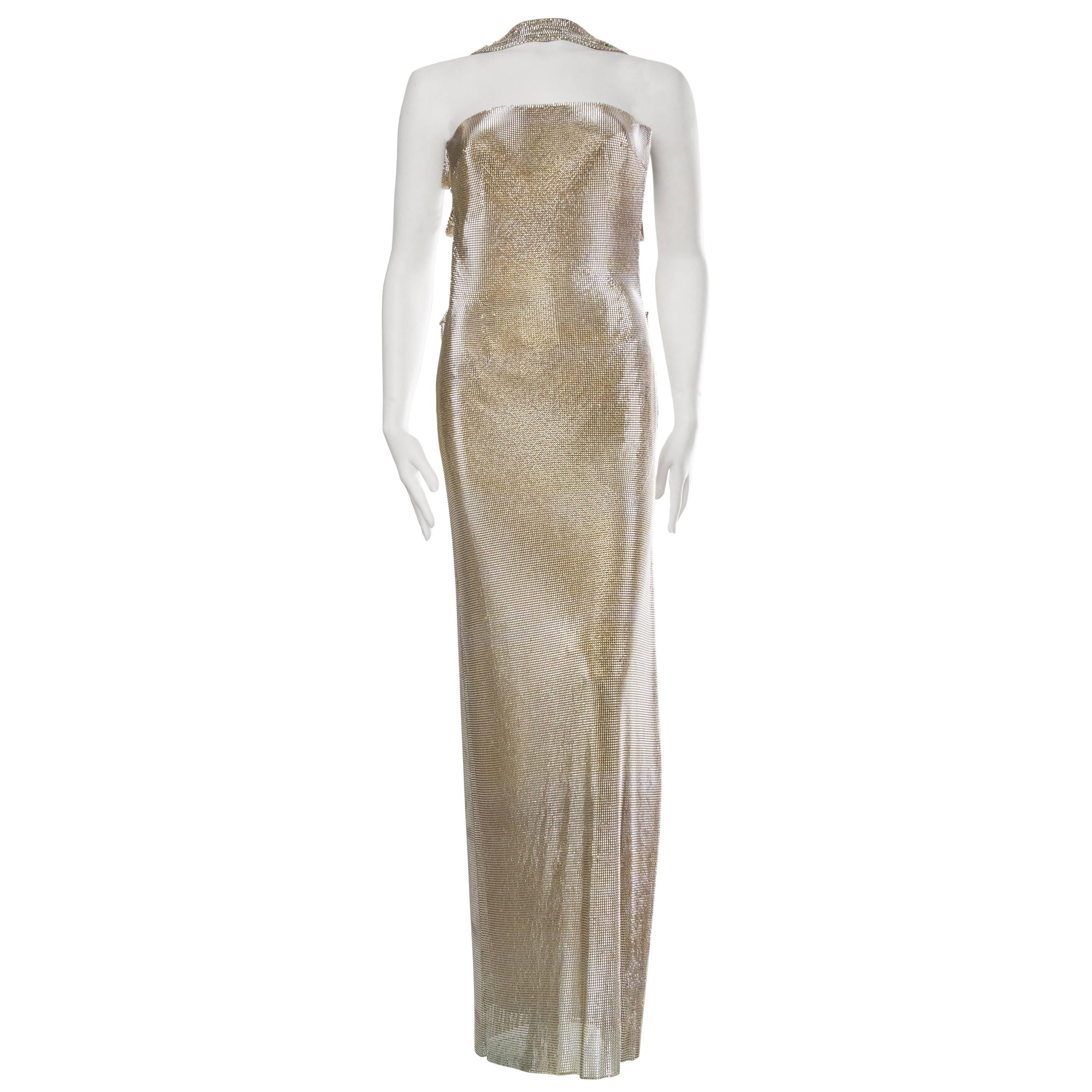 New with tags this shimmering gown has been ready to make her jaw-dropping entrance since the 1990s. The backless construction is a gorgeous design and the weight of the dress is supported by a fully boned and constructed bodice with one strap