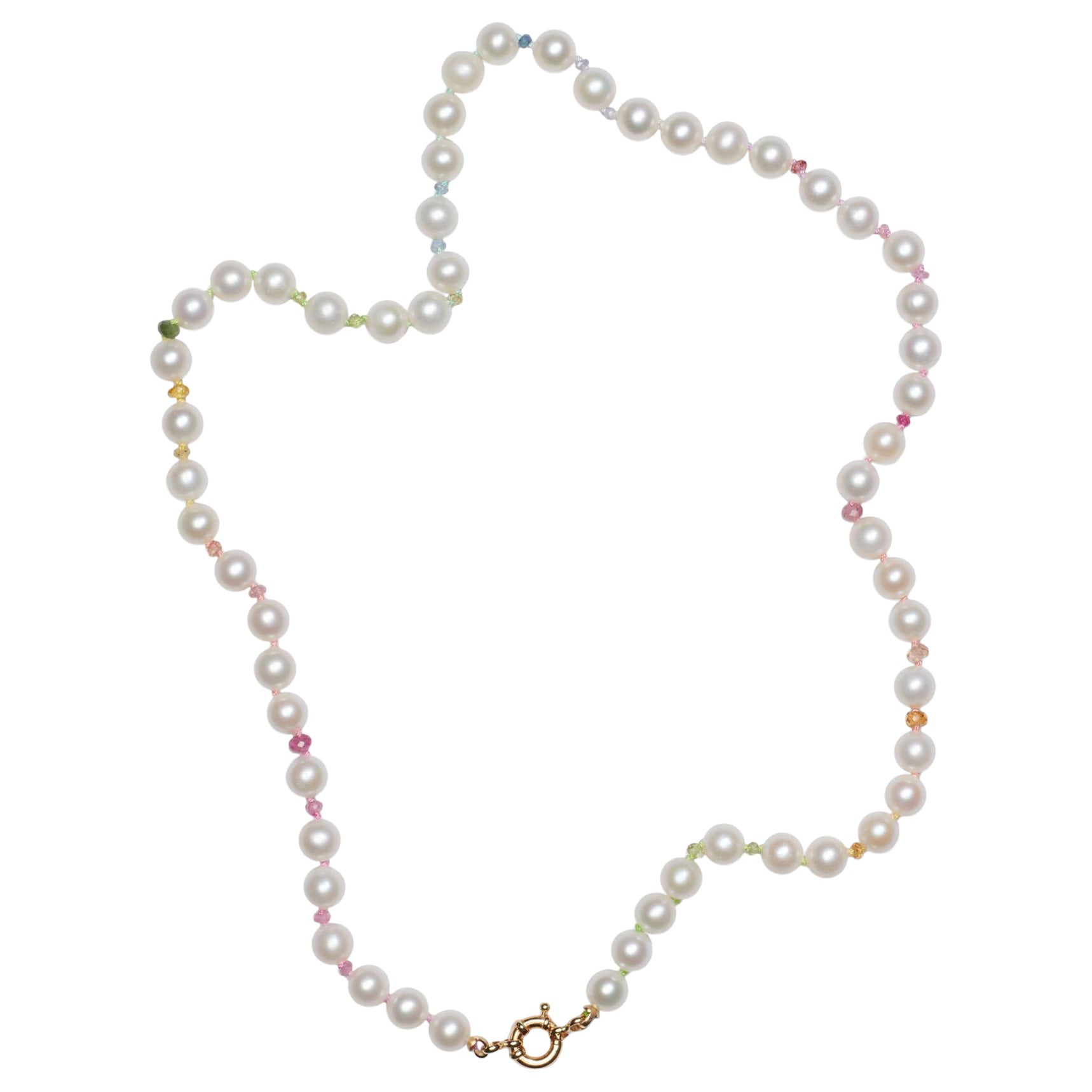 Le collier classique de perles blanches avec des perles de 6 mm, des saphirs multicolores étincelants et d'autres pierres précieuses ! Les couleurs suivent le modèle de l'arc-en-ciel, noué à la main sur un fil de soie multicolore, terminé par un