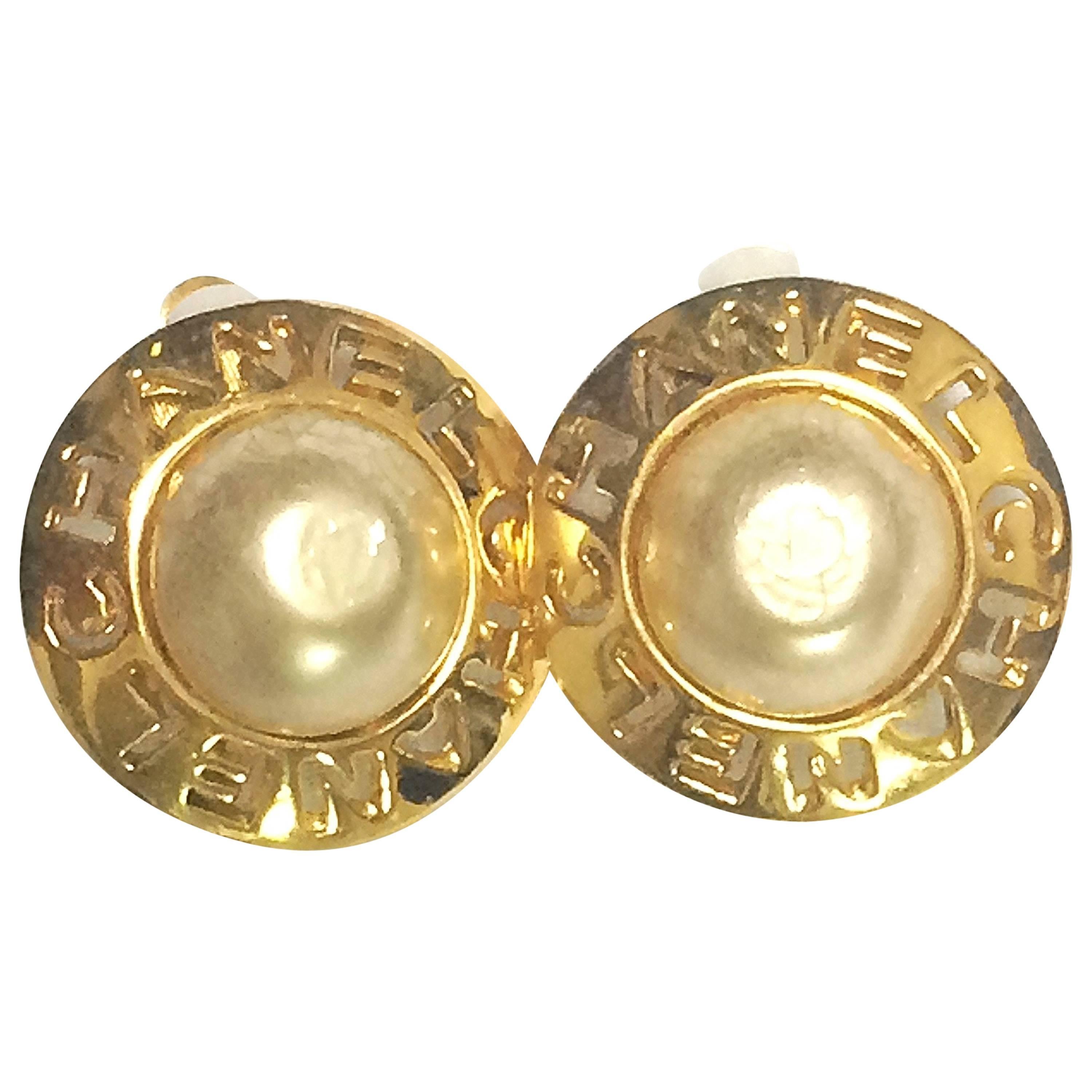 Vintage CHANEL golden round shape faux pearl earrings with cutout logo. Chic.