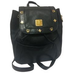 80's Vintage MCM genuine leather black backpack with golden logo motifs. Unisex