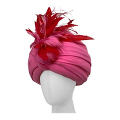 Turban en crêpe de soie rose pivoine fait sur mesure avec des plumes rouges et roses sur le devant
