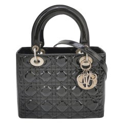Bolso mediano Lady Dior de charol negro con herrajes plateados