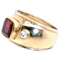 Anello a fascia larga in oro giallo e bianco 18 carati con granato e diamanti incastonati