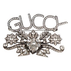 Gucci Broche logo ornée de cristaux argentés