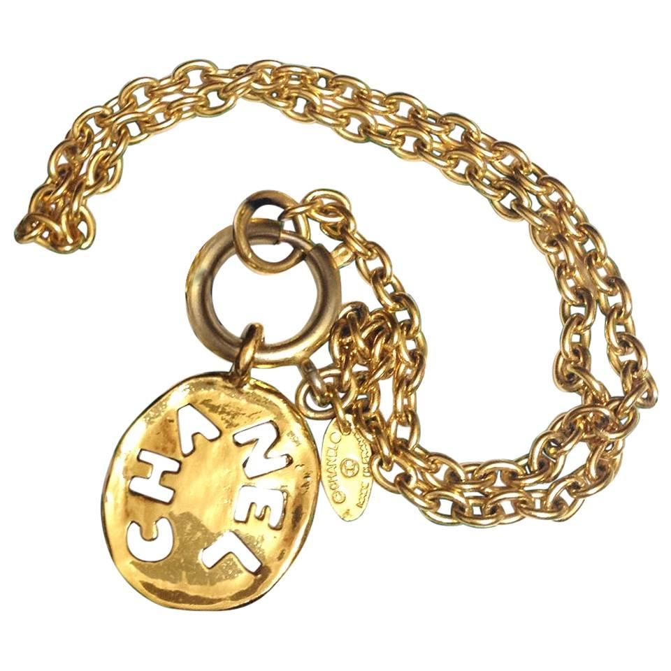 Vintage CHANEL golden chain necklace with cutout logo coin charm.