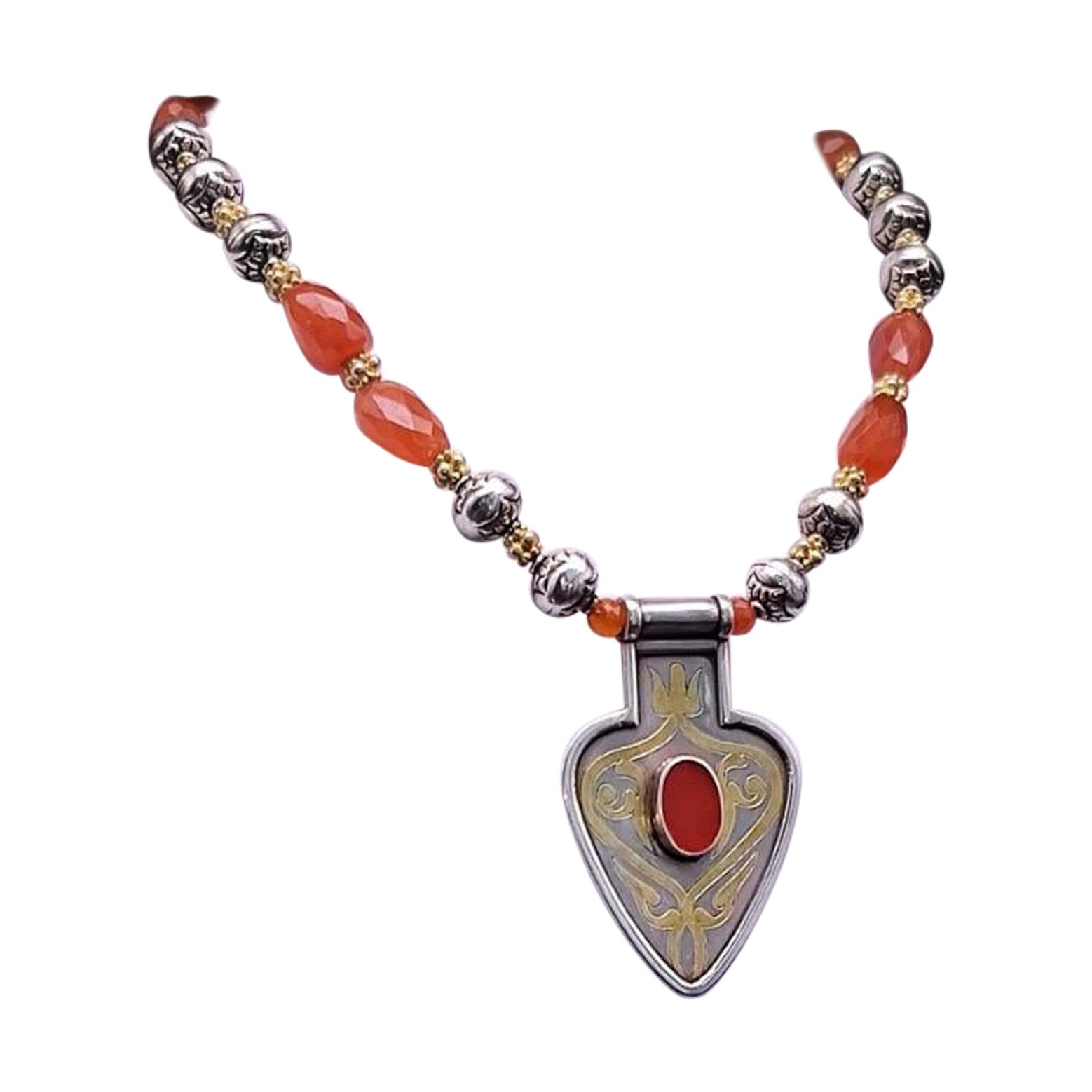 Questa straordinaria collana unica nel suo genere presenta perline di corniola sfaccettate e lucidate, completate da perline in argento sterling dal design intricato per un'estetica audace ma raffinata. Il cuore è un notevole ciondolo in stile