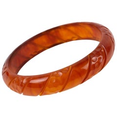 Bracelet jonc sculpté en bakélite et marbre ambré rouge translucide