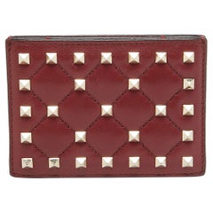 Tarjetero Rockstud Spike de piel acolchada burdeos de Valentino