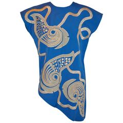 Tunique bleue asymétrique avec détails brodés de lamés et d'œillets dorés