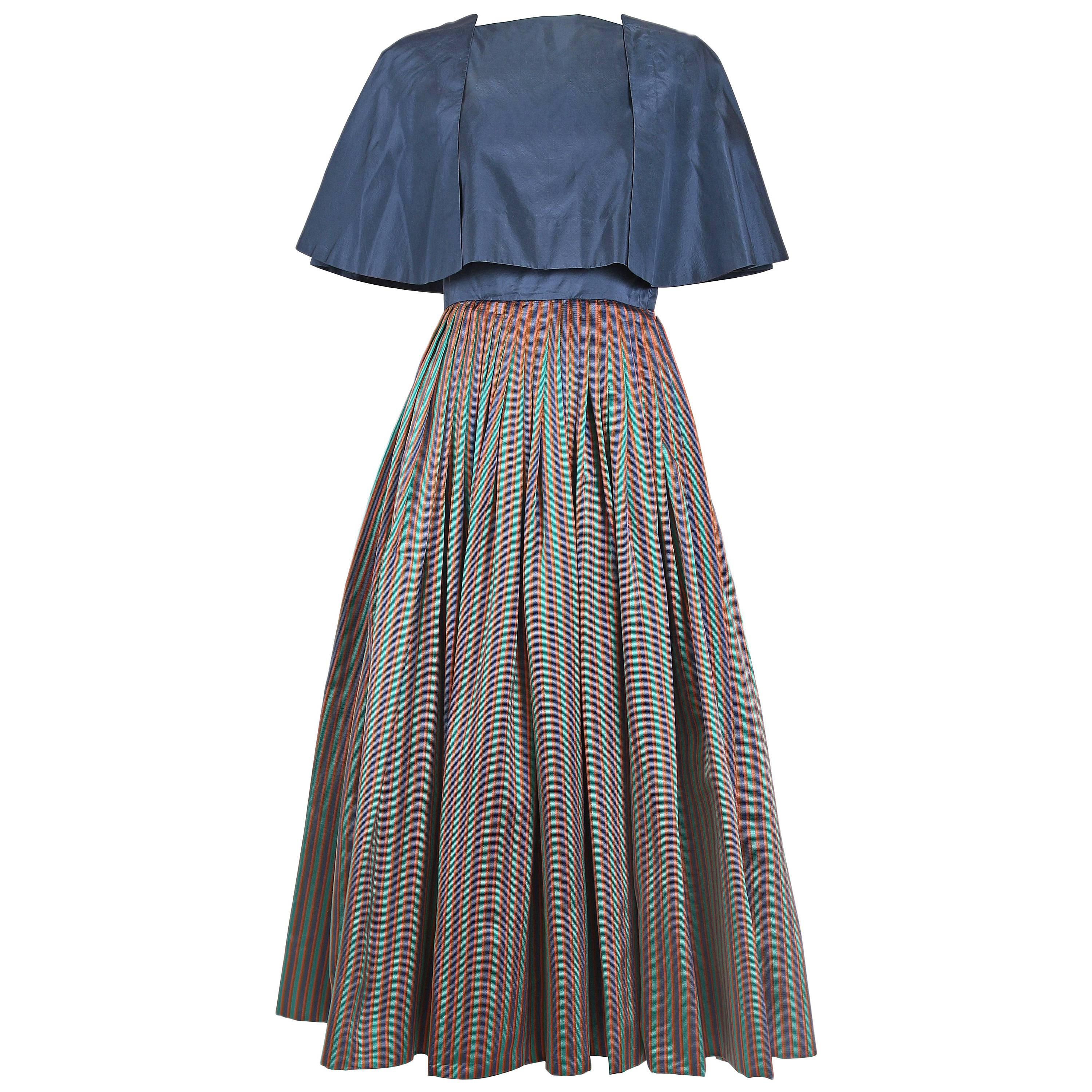 1983 Madame Gres haute couture cocktail dress featuring a blue silk taffeta bodice w/thin spaghetti straps and a voluminous/pleated silk skirt w/blue, green, orange, and brown vertical stripes. Skirt is lined at the interior with blue silk taffeta