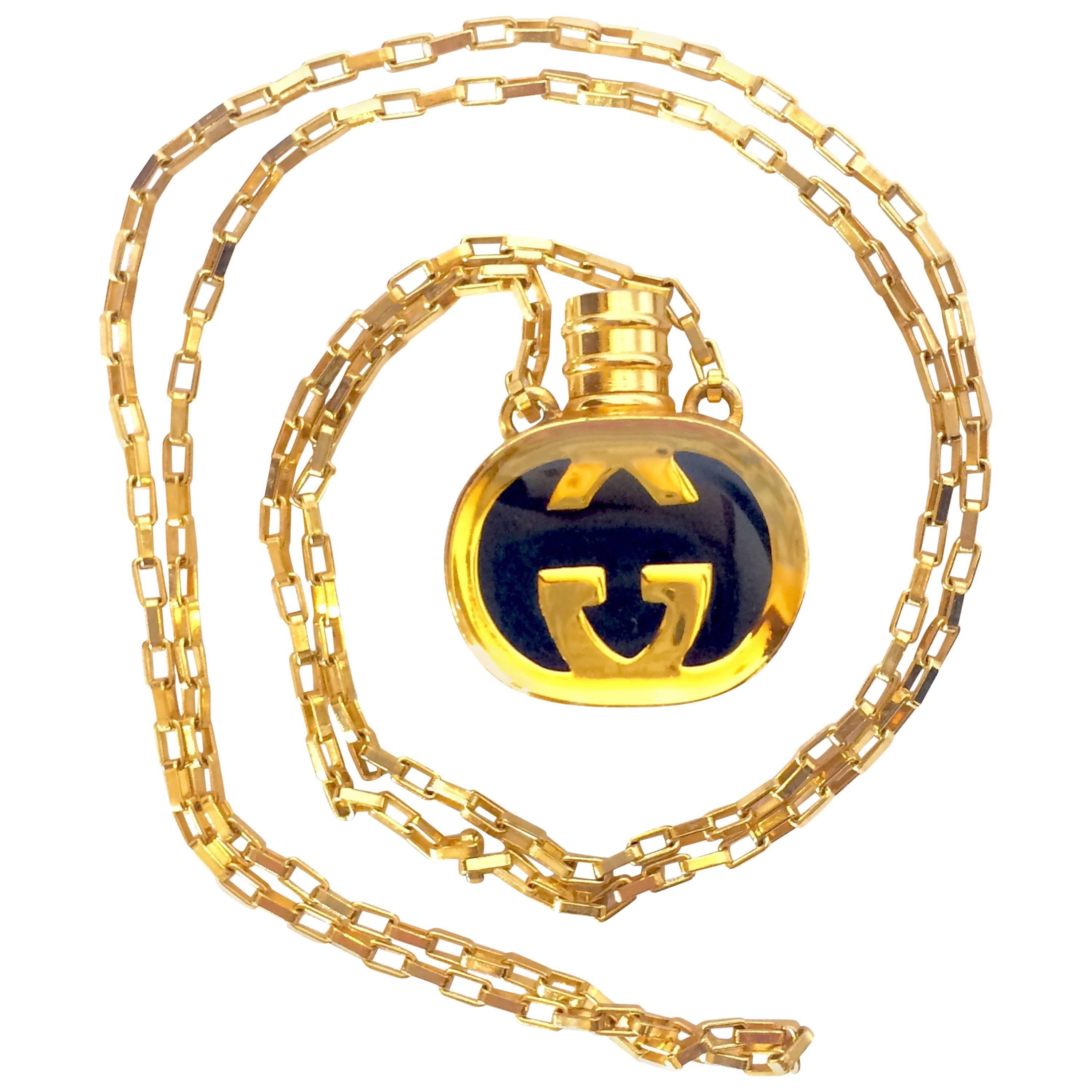 Vintage Gucci gold and navy round shape perfume bottle necklace with logo mark.