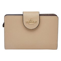 Portefeuille compact à fermeture éclair en cuir beige de Coach